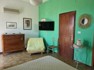 Cette chambre comprend un lit, une commode et une télévision. dans l'établissement B&B Ondamarina, à Lascari