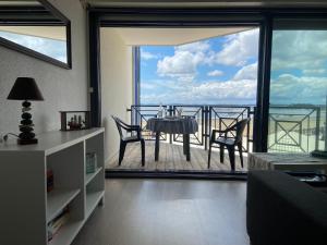 a living room with a table and chairs on a balcony at T2 Vue exceptionnelle sur le bassin d'Arcachon in Andernos-les-Bains