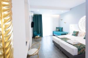 a hotel room with two beds and a blue couch at Likio Studios in Batsi
