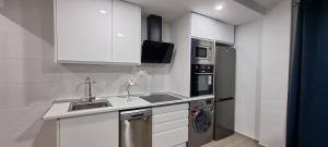 La cuisine est équipée de placards blancs, d'un évier et d'un lave-vaisselle. dans l'établissement Apartamento Habana, à Benidorm