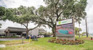 un cartel en el césped frente a un edificio en Equus Inn I75, en Ocala