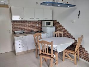 a kitchen with a table and chairs and a brick wall at Beti Blu, Kaninska vas in Bovec