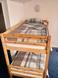 ein Etagenbett aus Holz mit einer karierten Decke darauf in der Unterkunft Beti Blu, Kaninska vas in Bovec