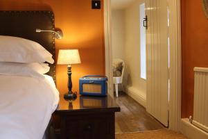 ロング・コンプトンにあるザ レッド ライオン インのベッド1台、時計1台が備わる客室です。