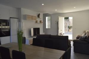 a living room with a table and a couch at CASA CARAVINA in Benimantell