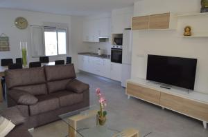 a living room with a couch and a tv at CASA CARAVINA in Benimantell