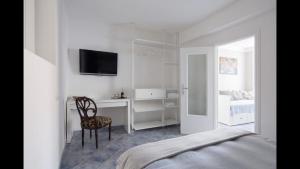 Dormitorio con cama, escritorio y TV en La Linea D'Acqua Apartment, en Manarola