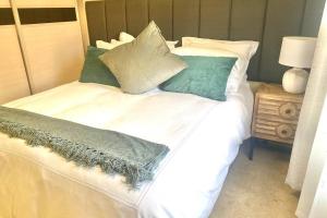ein Bett mit grünen und weißen Kissen darauf in der Unterkunft Phoenix Rising Apartment in Midrand