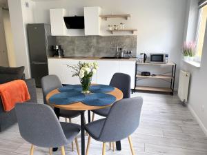 a kitchen and dining room with a table and chairs at Kosmo Apartament in Wrocław