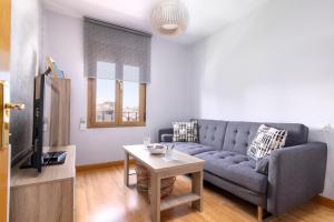 a living room with a couch and a table at Apartamento La Muralla - leonapartamentos in León