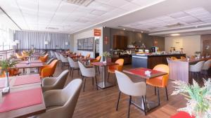 a restaurant with tables and chairs and a bar at Hotel 10 Palmas in Palmas