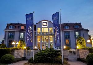 a building with blue flags in front of it at Great Polonia Ustka in Ustka