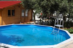 a swimming pool with a chair in front of a house at Casinha do Canto in Góis