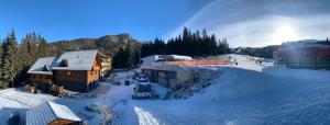 a snow covered mountain with a ski lodge at YASNA Apartments in Demanovska Dolina