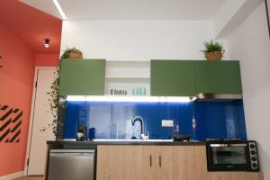una cucina con armadi verdi e blu e un lavandino di Valory #1,3 Aesthetic Stay a Salonicco