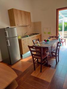 una cucina con tavolo, sedie e frigorifero di Summer's House a Borgagne