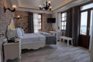 ein Schlafzimmer mit einem weißen Bett und einem großen Fenster in der Unterkunft Cunda Taka in Ayvalık