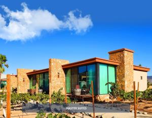 a house with glass and stone walls at Entre Viñedos by Hotel Boutique Valle de Guadalupe in Valle de Guadalupe