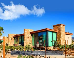 een huis met glas en stenen muren bij Entre Viñedos by Hotel Boutique Valle de Guadalupe in Valle de Guadalupe