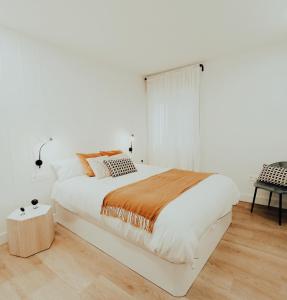 - une chambre blanche avec un grand lit et une fenêtre dans l'établissement OH MY HOME BILBAO, à Bilbao