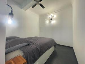 - une chambre avec un lit et deux lumières sur le mur dans l'établissement L'Atelier de l'Amiral - Parking - Centre Historique, à Grasse