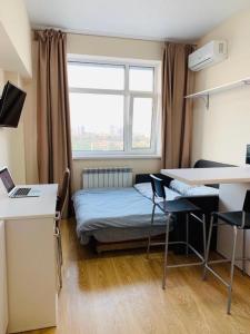 een kamer met een bed, een bureau en een raam bij Apartments Orange in Kiev