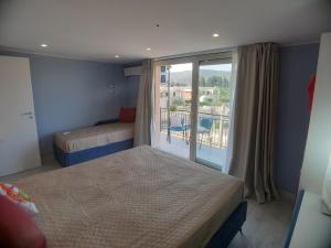 um quarto de hotel com duas camas e uma varanda em Stella-Guesthouse em Solarino