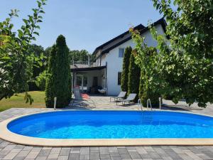 an outdoor swimming pool in front of a house at GreenWood Residence in Timişoara