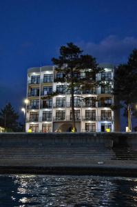 un gran edificio blanco con un árbol delante en Hotel Medusa, en Kobuleti