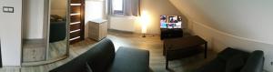 Habitación con vistas a una sala de estar con sofá y TV. en Zacisze en Gdansk