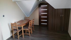 una sala da pranzo con tavolo e sedie in legno di Zacisze a Danzica
