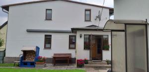 a white house with a bench in front of it at Two-Bedroom Apartment in Uckeritz (Seebad) I in Ueckeritz