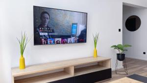 uma sala de estar com uma televisão de ecrã plano na parede em Polonia ART Apartments in the City Center em Katowice