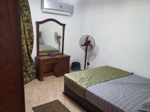 Schlafzimmer mit einem Bett, einem Spiegel und einem Ventilator in der Unterkunft Chalet first floor two bedrooms In Stella De Mare Ain El Sokhna For Families only in Ain Suchna