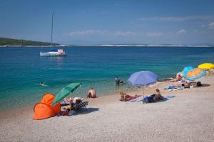a group of people on a beach with umbrellas at Apartment in Silo/Insel Krk 13562 in Šilo