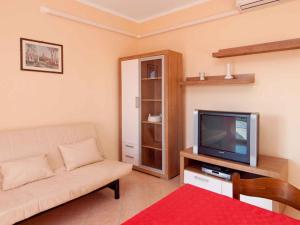 a living room with a couch and a tv at Apartment in Rabac 16819 in Rabac