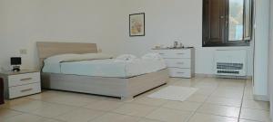sypialnia z łóżkiem i komodą w obiekcie Sa Teria Village - Camere Deluxe - w mieście Tertenìa