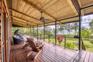 博卡斯德尔托罗Oasis Bluff Beach的房子上的露天平台,摆放着椅子和吊床。