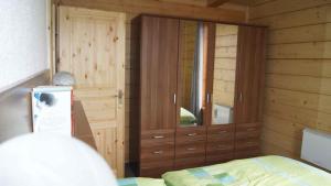 a bedroom with a large wooden cabinet and a bed at Holiday home in Friedland 2712 in Friedland