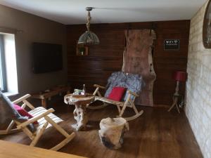 a living room with chairs and a table and a tv at Gîte La Grange de La Trigalle avec spa professionnel privatif in Valognes