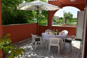 una mesa y sillas bajo una sombrilla en un patio en Villa Orih, en Krnica