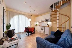 a living room with a blue couch and a kitchen at Apartment in Lucca/Toskana 23961 in San Cassiano a Moriano