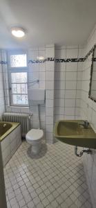 een badkamer met toilet, bad en wastafel bij Handwerker Unterkunft Monteurzimmer mit Gemeinschaftsbad in Brebach in Saarbrücken +10 foto's