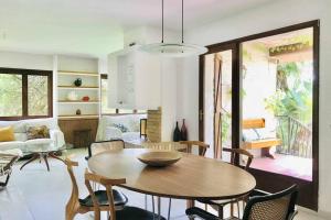 Casa mediterránea con gran jardín y piscina a 500 m de la playa في رودا دي بارا: غرفة معيشة مع طاولة وكراسي خشبية