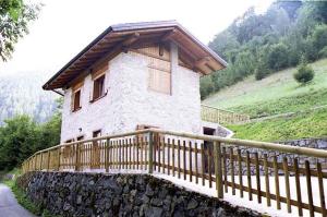 un edificio con una valla de madera delante de él en Holiday home in Tiarno di Sotto 23505, en Tiarno di Sotto