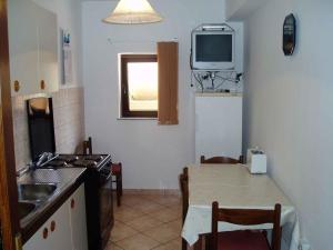 a kitchen with a table and a tv on the wall at Two-Bedroom Apartment in Senj I in Nehaj