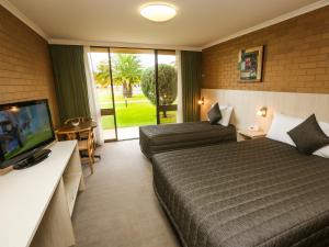 a hotel room with two beds and a flat screen tv at Mildura River City Motel in Mildura