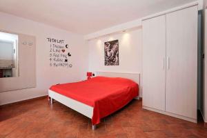 - une chambre avec un lit et une couverture rouge dans l'établissement Studio Apartment in Vrsar I, à Vrsar
