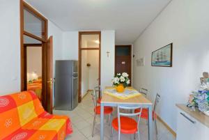 a living room with a table and chairs and a kitchen at Apartment in Bibione 24409 in Bibione
