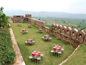 un gruppo di tavoli e sedie in un campo di The Dadhikar Fort Alwar a Alwar